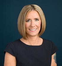 Smiling woman with blonde hair, wearing a professional shirt